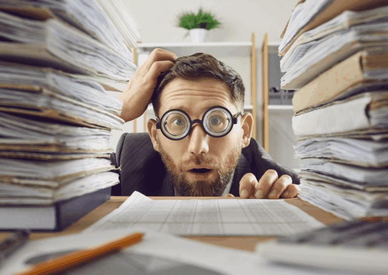Paperwork piling up of a man in glasses